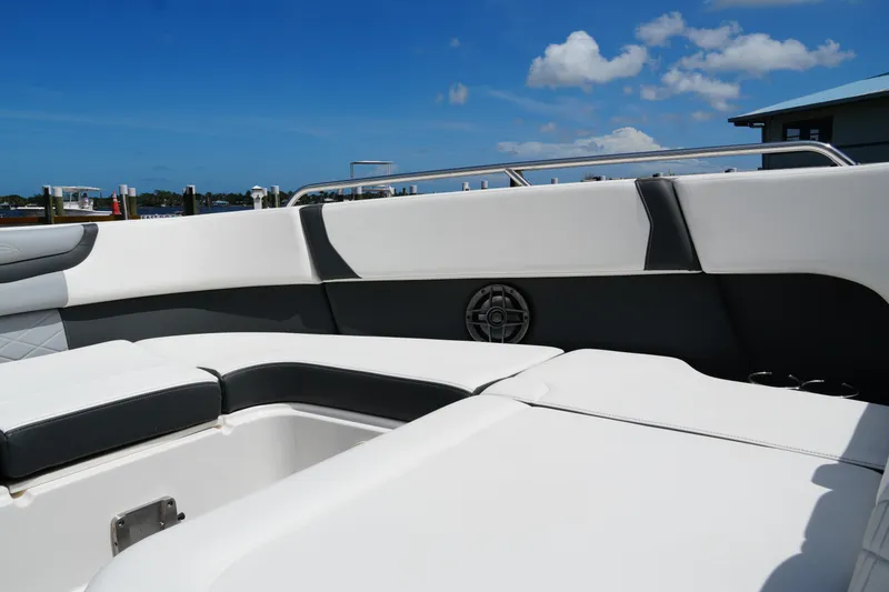 Slide: The Image of 2022 Chaparral 280 OSX boat interior with white seating and blue sky background. - 48
