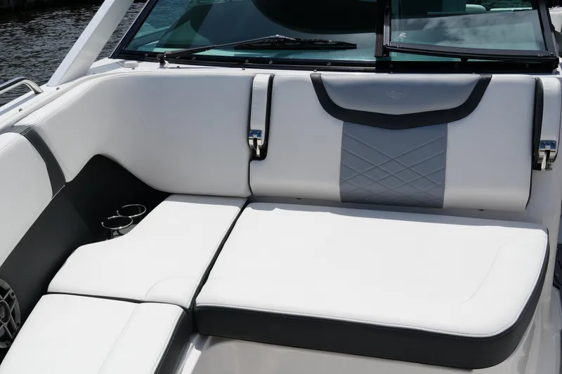 Slide: The Image of 2022 Chaparral 280 OSX boat interior with white cushioned seating and cup holders. - 49