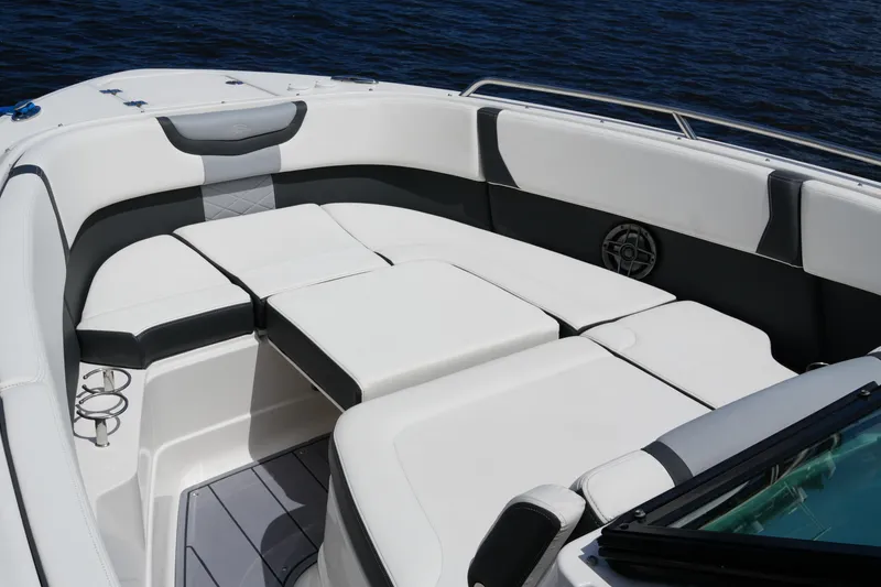 Slide: The Image of 2022 Chaparral 280 OSX boat interior with white cushioned seating and cup holders. - 52