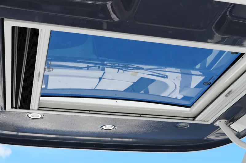 Slide: The Image of Sunroof of 2022 Chaparral 280 OSX boat, showcasing sleek design and blue sky reflection. - 57