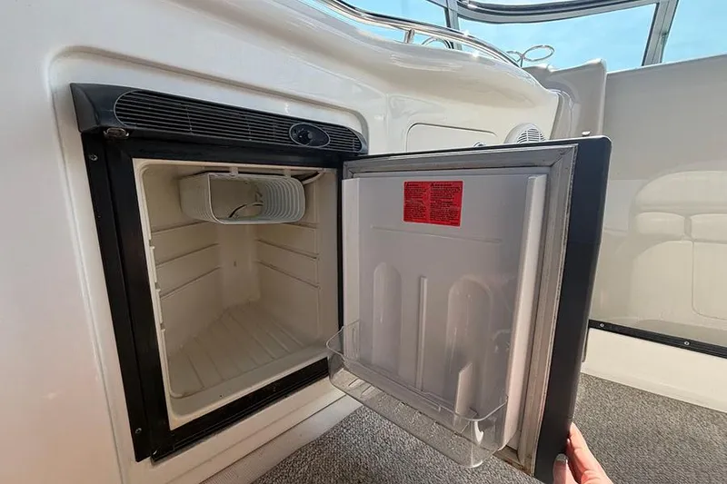 Slide: The Image of Open refrigerator on 2007 Sea Ray 300 Sundancer boat, showing interior storage space. - 12
