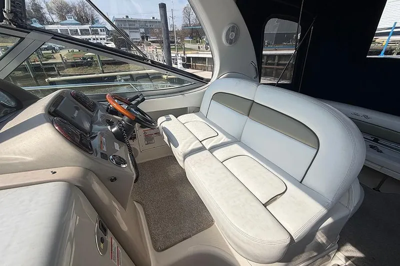Slide: The Image of 2007 Sea Ray 300 Sundancer cockpit with white seating and steering wheel. - 16