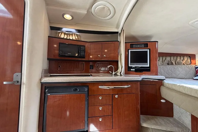 Slide: The Image of 2007 Sea Ray 300 Sundancer cabin interior with kitchenette, microwave, and TV. - 19