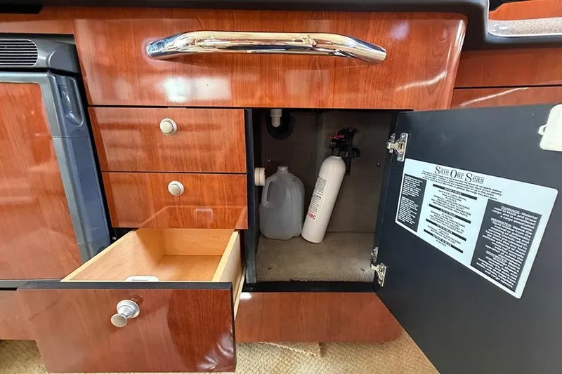 Slide: The Image of 2007 Sea Ray 300 Sundancer interior cabinet with open drawer and safety equipment. - 20