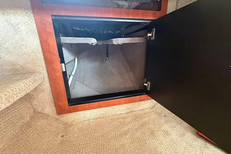 Slide: The Image of Open storage compartment inside 2007 Sea Ray 300 Sundancer boat, featuring carpeted interior. - 23