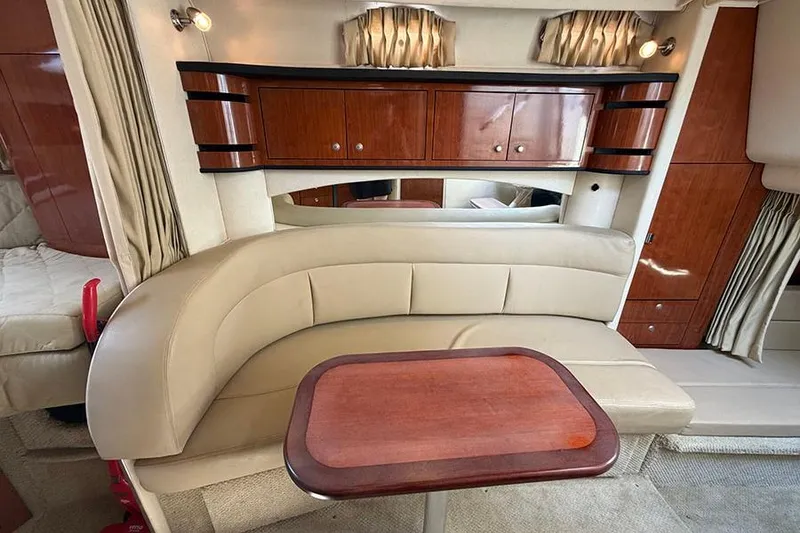 Slide: The Image of Interior of 2007 Sea Ray 300 Sundancer with beige seating and wooden cabinetry. - 25