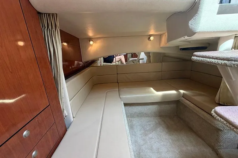 Slide: The Image of Interior of 2007 Sea Ray 300 Sundancer yacht with beige seating and wooden cabinetry. - 29