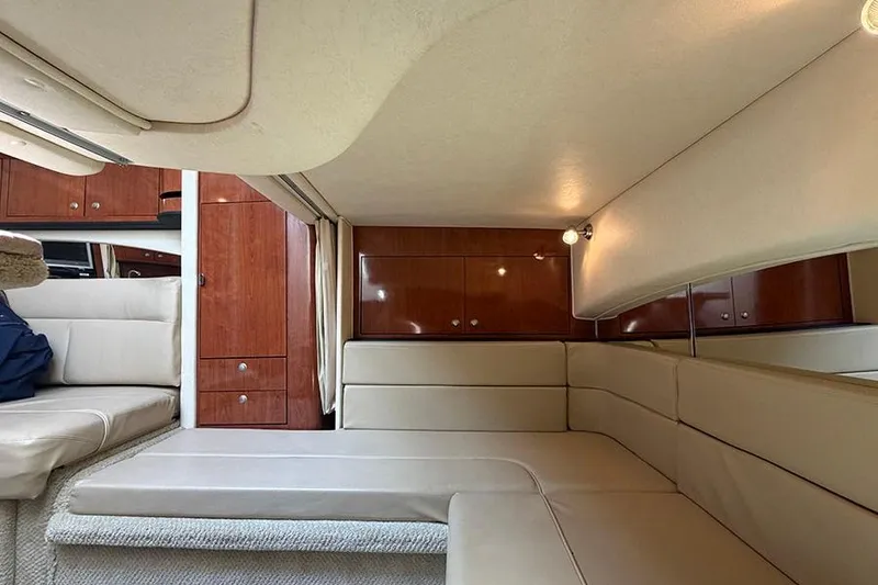 Slide: The Image of Interior of 2007 Sea Ray 300 Sundancer with beige seating and wooden cabinetry. - 30