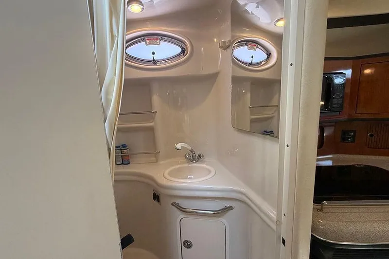Slide: The Image of 2007 Sea Ray 300 Sundancer bathroom with sink, mirror, and porthole windows. - 37