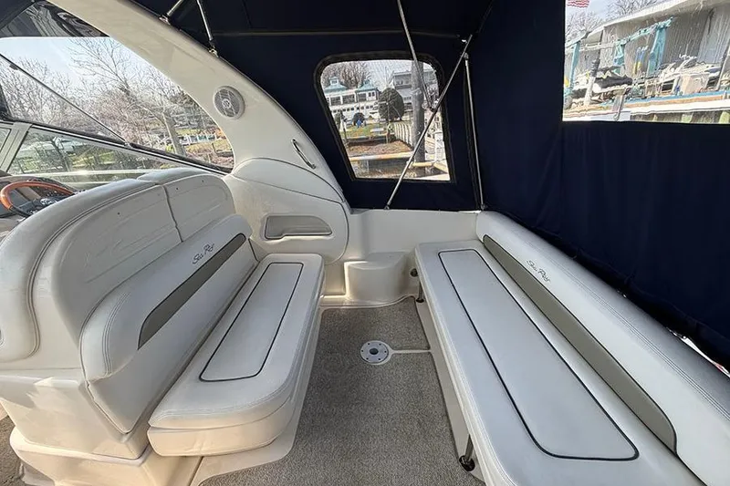Slide: The Image of Interior of 2007 Sea Ray 300 Sundancer boat with cushioned seating and blue canopy. - 6