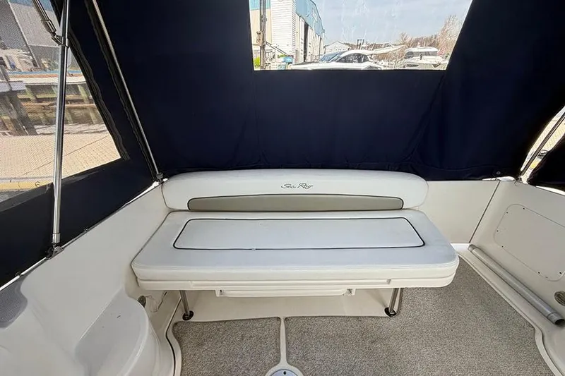 Slide: The Image of 2007 Sea Ray 300 Sundancer interior with cushioned seating and navy canopy. - 7