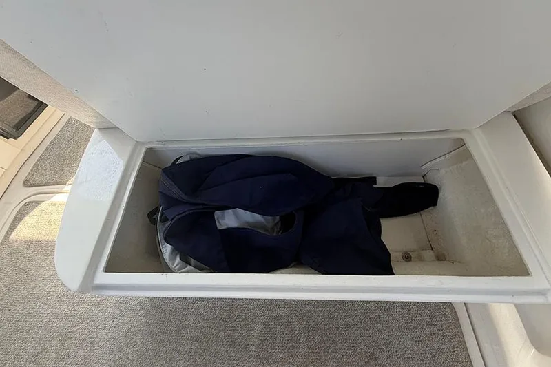 Slide: The Image of Storage compartment on a 2007 Sea Ray 300 Sundancer boat with clothing inside. - 9