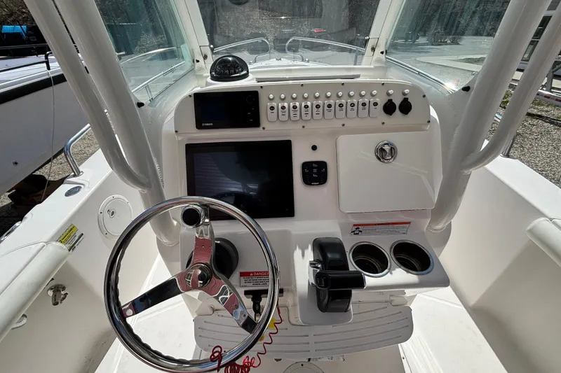 Slide: The Image of 2011 Everglades 230 Center Console boat dashboard with steering wheel and controls. - 2