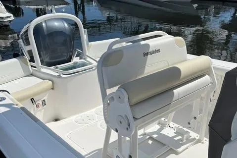 Slide: The Image of 2011 Everglades 230 Center Console boat interior with seating and helm, docked by the water. - 3