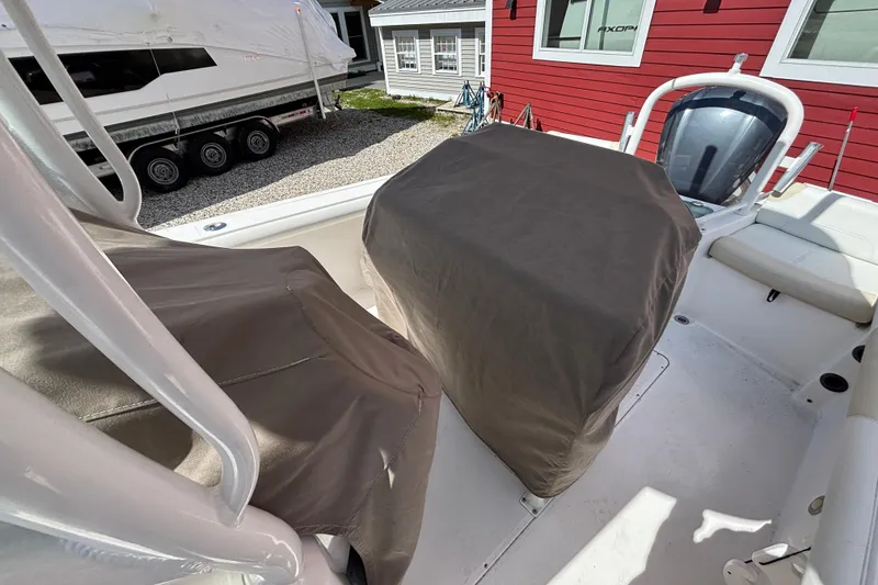 Slide: The Image of 2011 Everglades 230 Center Console boat with covered seats and console, docked near a red building. - 30