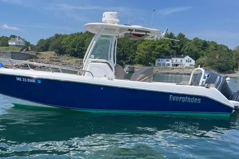 Slide: The Image of 2011 Everglades 230 Center Console boat on water, coastal background, clear sky. - 7