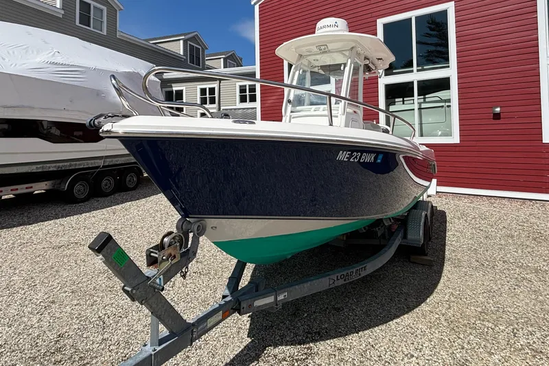 Slide: The Image of 2011 Everglades 230 Center Console boat on trailer, parked near red building. - 8