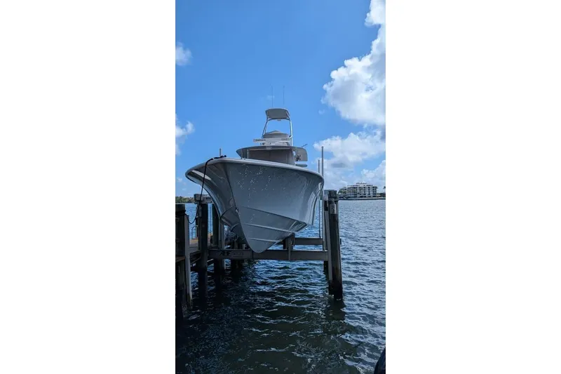 Slide: The Image of 2022 SeaVee 390Z boat docked on a lift, under a clear blue sky. - 8