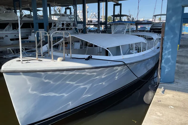 The Image of 1979 Willard Marine 50 Utility Launch docked in a marina under a covered area. - 0
