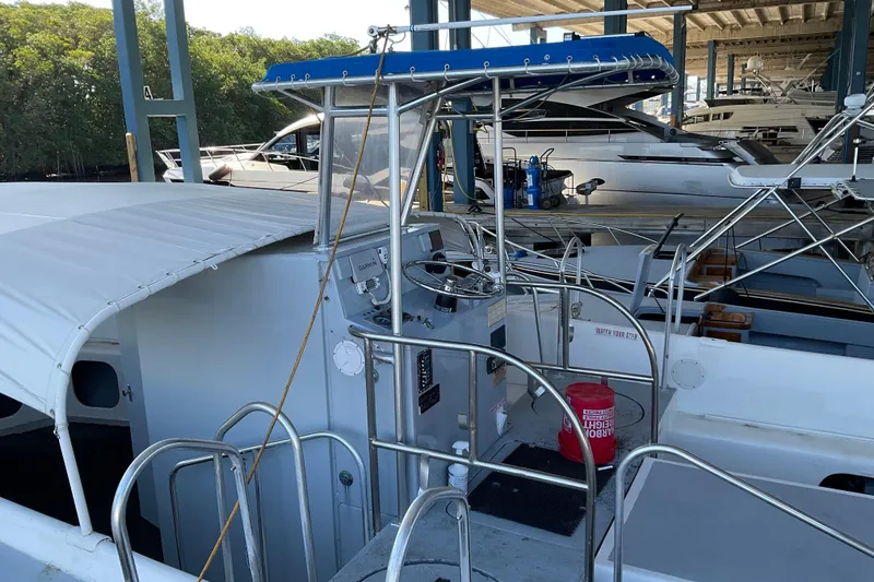 Slide: The Image of 1979 Willard Marine 50 Utility Launch with blue canopy, docked in a marina. - 1