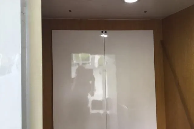 Slide: The Image of Interior of a 1979 Willard Marine 50 Utility Launch with white cabinets and wood paneling. - 13