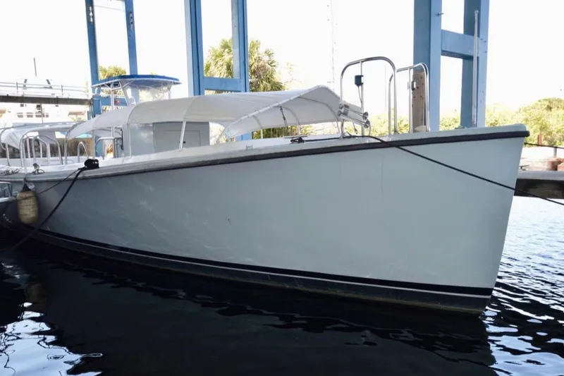 Slide: The Image of 1979 Willard Marine 50 Utility Launch docked at marina, featuring white canopy and metal ladder. - 32