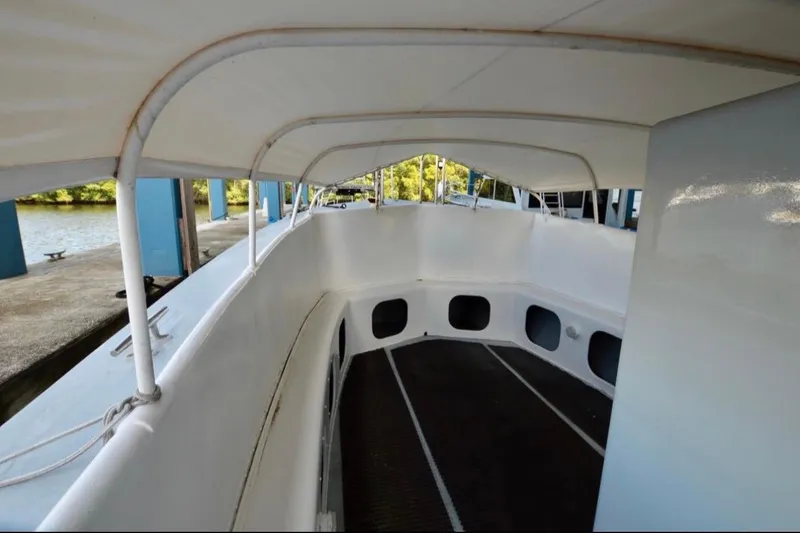 Slide: The Image of 1979 Willard Marine 50 Utility Launch interior with canopy, docked by the water. - 7