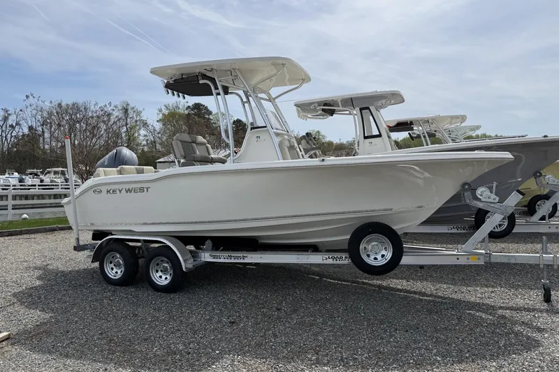 The Image of 2026 Key West 219 FS boat on trailer, parked outdoors, side view. - 0