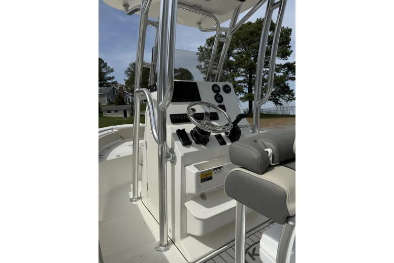 Slide: The Image of 2026 Key West 219 FS boat console with steering wheel and controls, docked outdoors. - 3