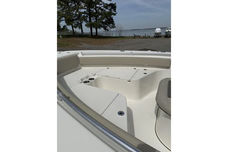 Slide: The Image of 2026 Key West 219 FS boat interior with seating and cup holders, dockside view. - 4