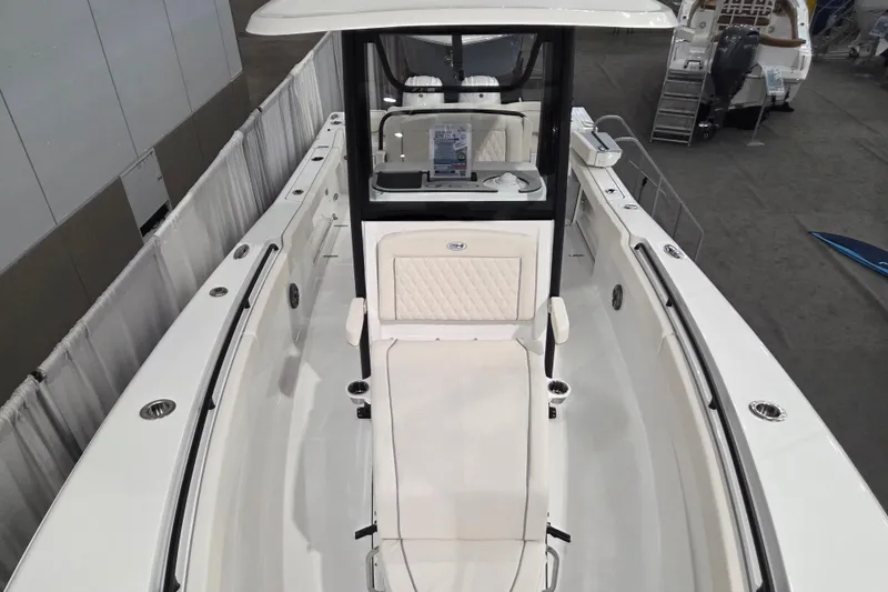 Slide: The Image of 2026 Sea Hunt Ultra 275 Coffin Box boat interior, showcasing seating and helm station at a boat show. - 12