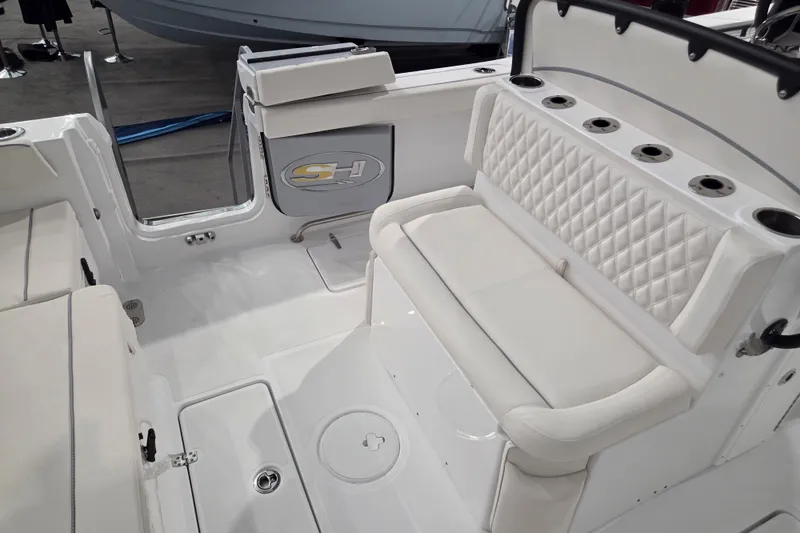 Slide: The Image of 2026 Sea Hunt Ultra 275 Coffin Box boat interior with white seating and rod holders. - 6