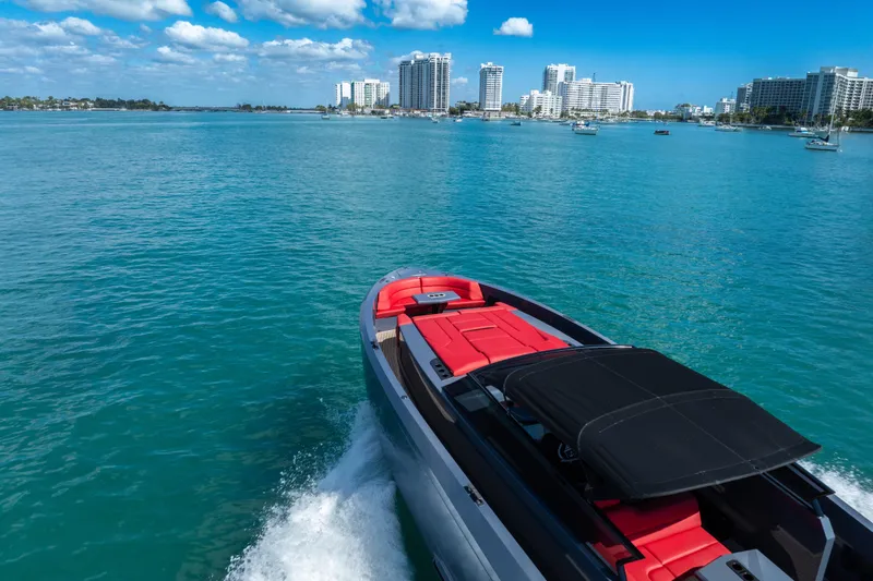 Slide: The Image of 2021 Vanquish Yachts 45 cruising in turquoise waters near a city skyline. - 10