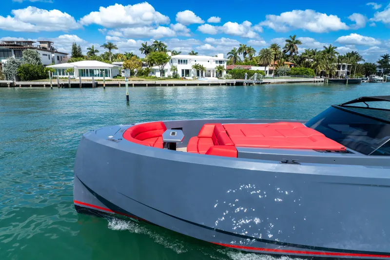 Slide: The Image of Vanquish Yachts 2021 model 45 cruising near luxury waterfront homes under a clear blue sky. - 14