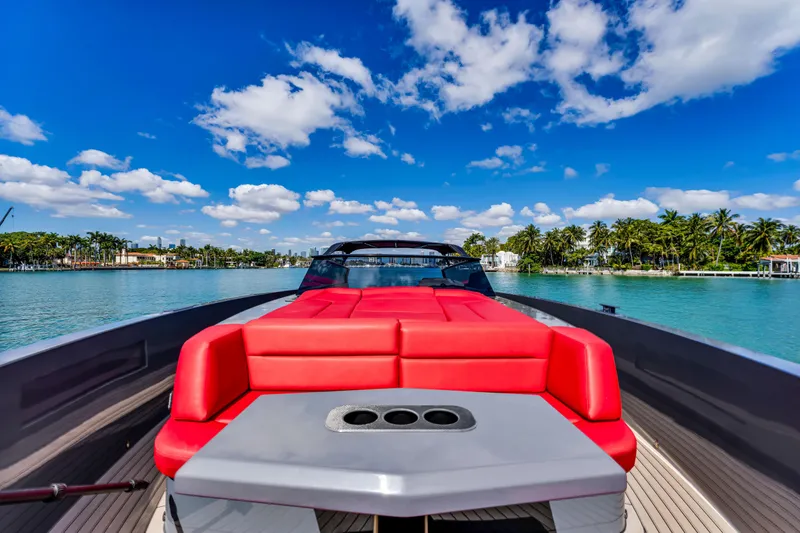 Slide: The Image of 2021 Vanquish Yachts 45 with red seating, cruising on a sunny day with palm trees. - 15