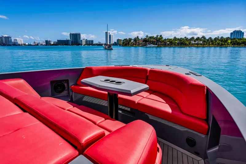 Slide: The Image of Luxurious 2021 Vanquish Yachts 45 with red seating, cruising near a city skyline. - 17