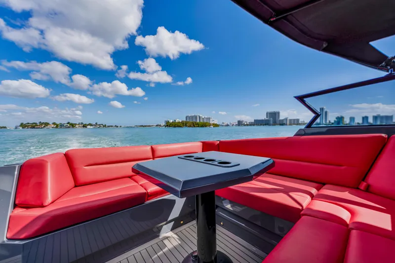 Slide: The Image of Luxurious Vanquish Yachts 45 with red seating, ocean view, and city skyline in the background. - 21