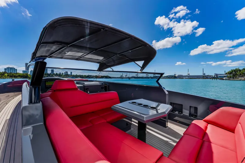 Slide: The Image of Luxurious 2021 Vanquish Yachts 45 with red seating, sleek design, and waterfront view. - 25