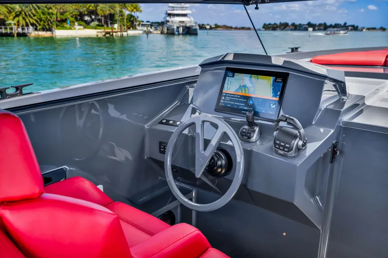 Slide: The Image of Helm of 2021 Vanquish Yachts 45 with red seating and navigation display. - 28