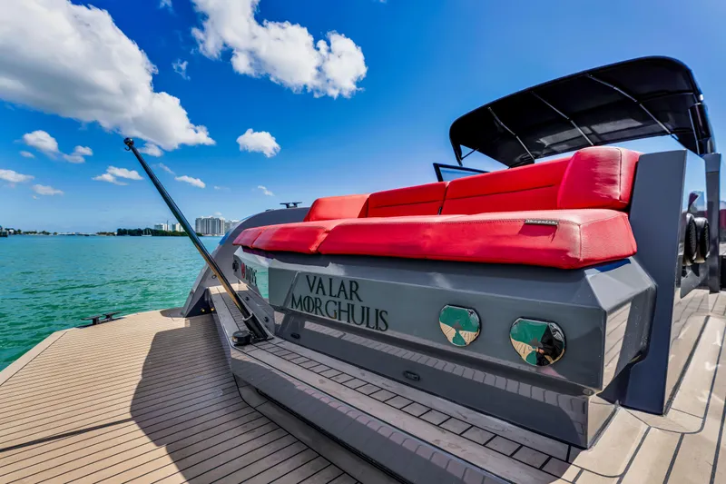 Slide: The Image of Vanquish Yachts 45, 2021 model, with red seating, on a sunny day by the water. - 3