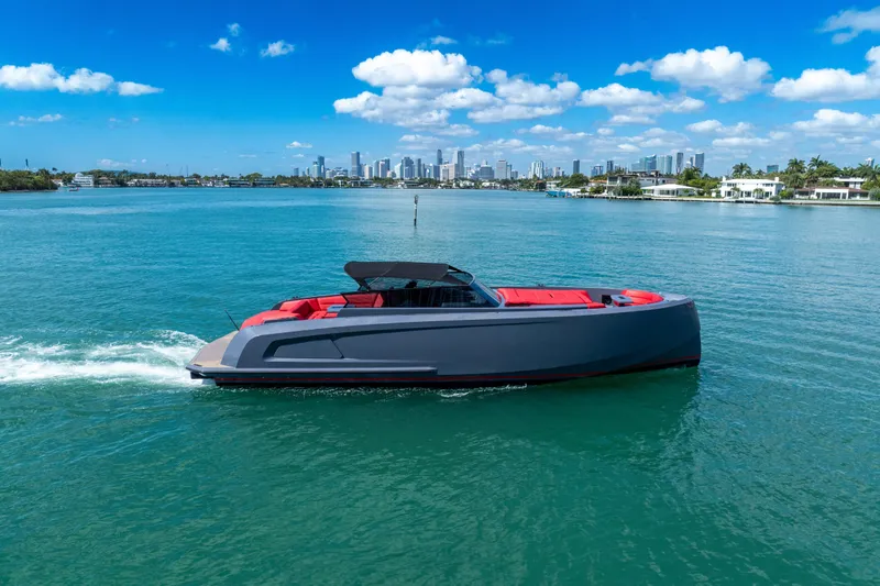 Slide: The Image of 2021 Vanquish Yachts 45 cruising on turquoise water with city skyline in background. - 7