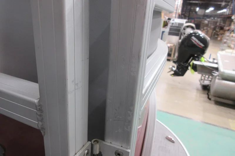 Slide: The Image of 2026 Sun Tracker SportFish 22 DLX boat detail with outboard motor in a warehouse. - 11