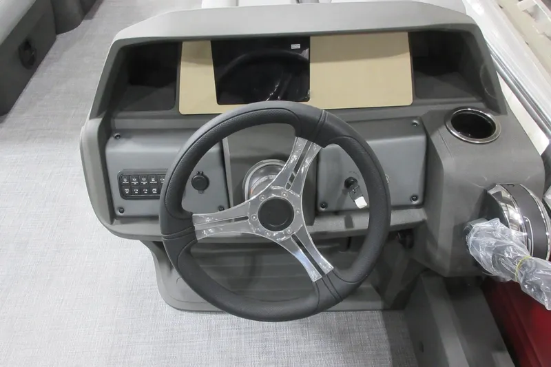 Slide: The Image of Steering console of 2026 Sun Tracker SportFish 22 DLX with modern controls and cup holder. - 3