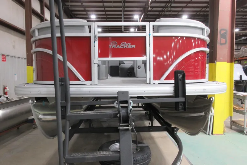 Slide: The Image of 2026 Sun Tracker SportFish 22 DLX pontoon boat in a warehouse setting. - 4