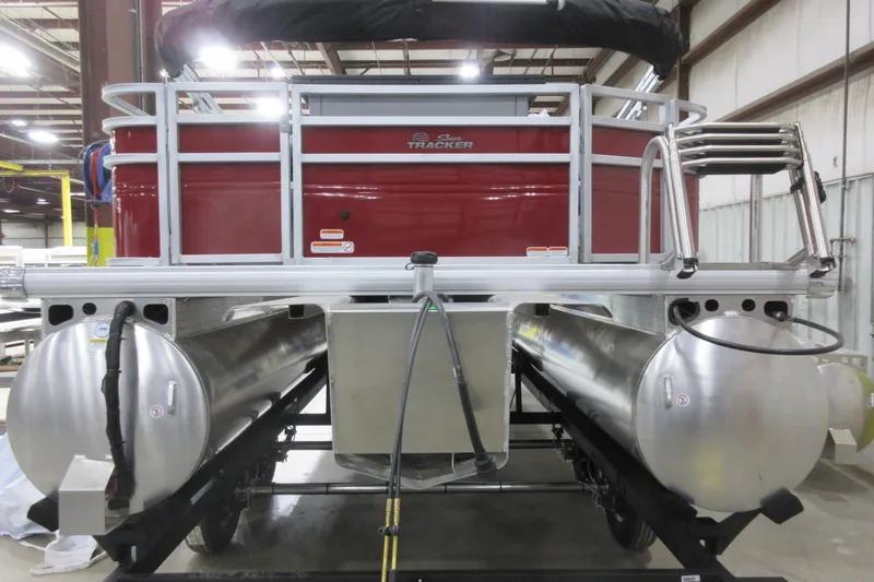Slide: The Image of 2026 Sun Tracker SportFish 22 DLX pontoon boat in a warehouse setting. - 5