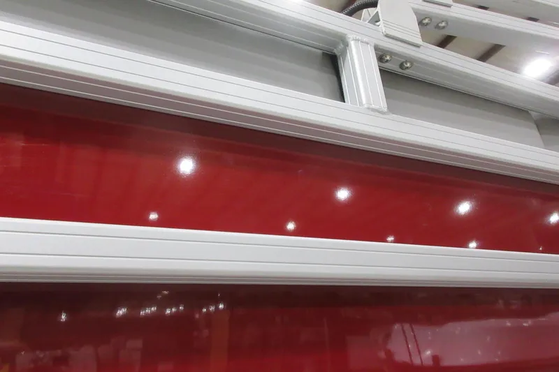 Slide: The Image of Close-up of 2026 Sun Tracker SportFish 22 DLX boat with red and silver detailing. - 9