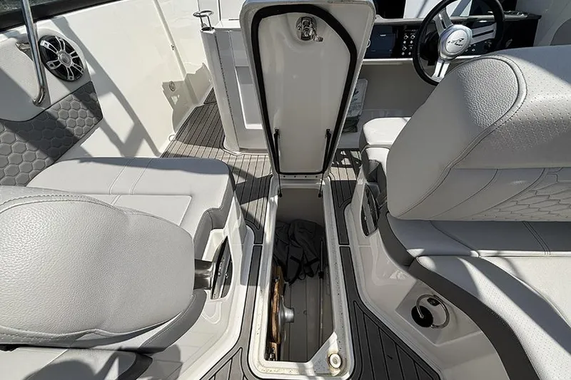 Slide: The Image of 2024 Sea Ray SDX 250 Outboard interior with open storage compartment and seating. - 11
