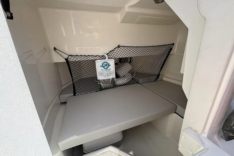 Slide: The Image of 2024 Sea Ray SDX 250 Outboard cabin interior with seating and storage net. - 18