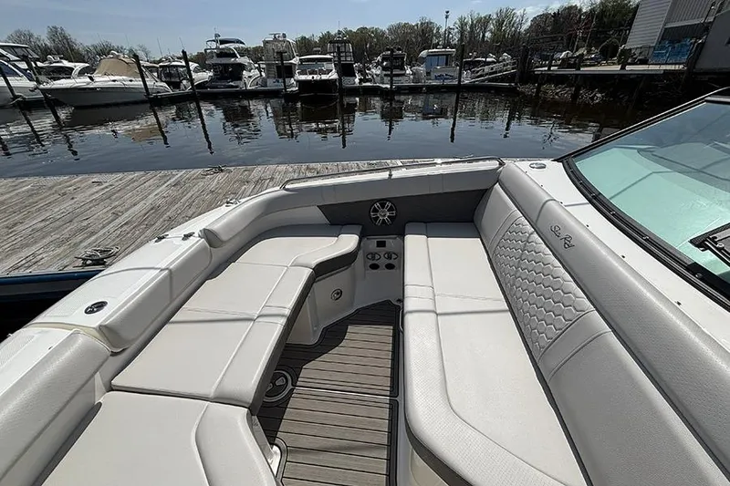 Slide: The Image of 2024 Sea Ray SDX 250 Outboard boat interior with luxurious seating at a marina. - 21