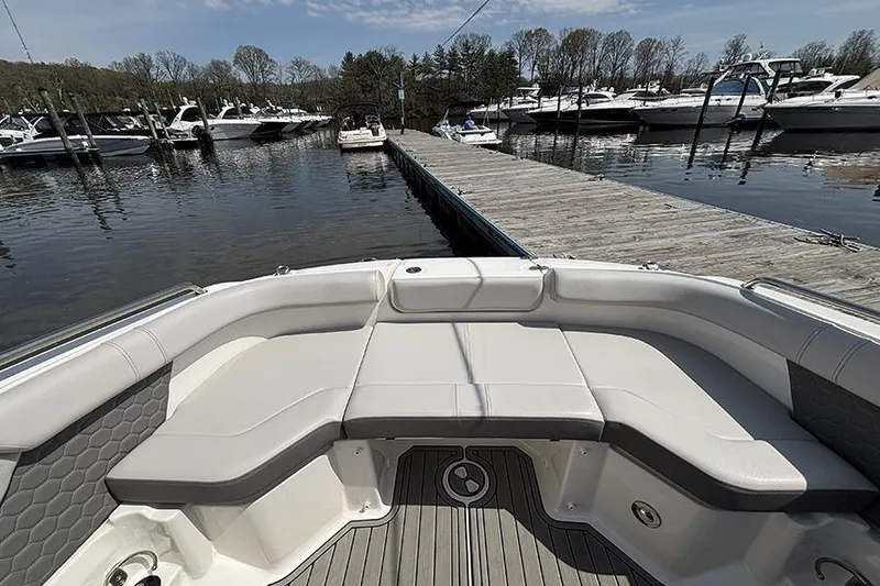 Slide: The Image of 2024 Sea Ray SDX 250 Outboard boat interior at marina dock, showcasing seating and watercraft. - 22